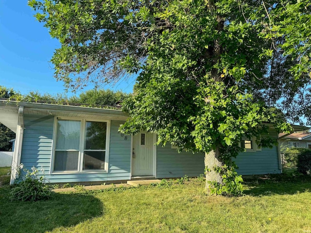 rear view of property featuring a lawn