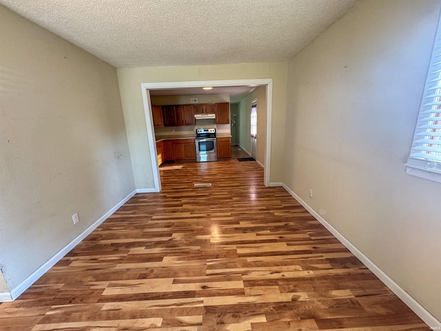 hall featuring wood-type flooring and a textured ceiling