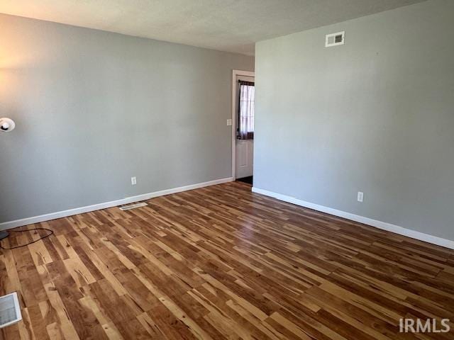 empty room with dark hardwood / wood-style floors