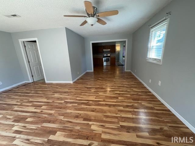 empty room featuring hardwood / wood-style floors, ceiling fan, and a textured ceiling