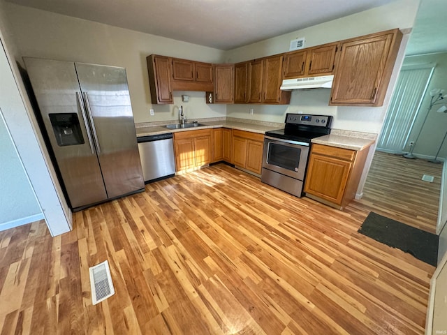 kitchen featuring sink, stainless steel appliances, and light hardwood / wood-style floors