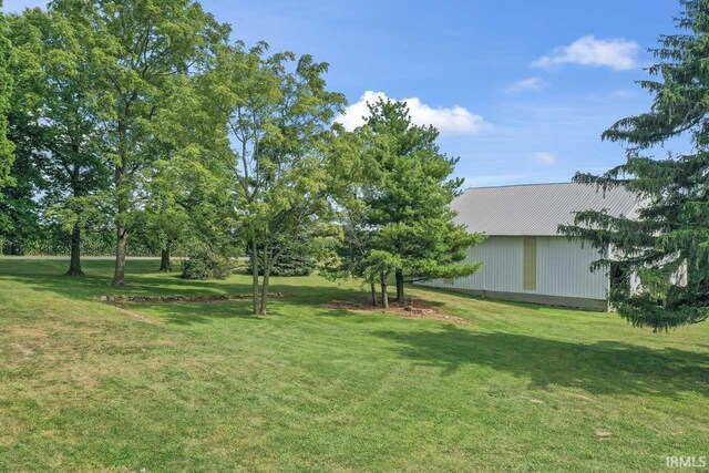 view of home's exterior with an outdoor structure and a yard