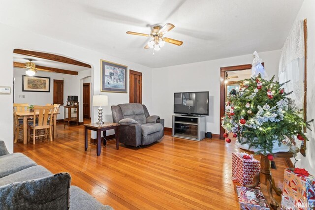 living room featuring ceiling fan, light wood-type flooring, and a textured ceiling