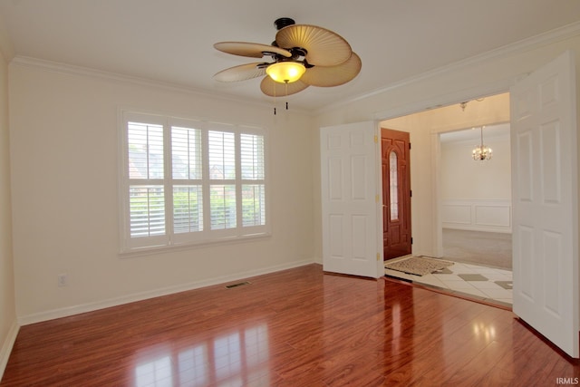 unfurnished room with ceiling fan with notable chandelier, ornamental molding, and hardwood / wood-style floors