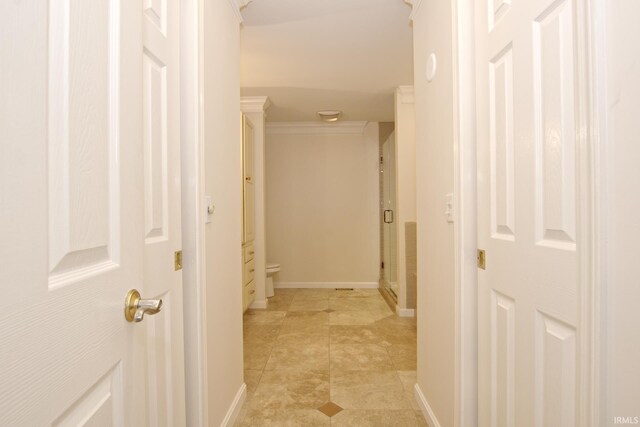 hall featuring ornamental molding and light tile patterned floors