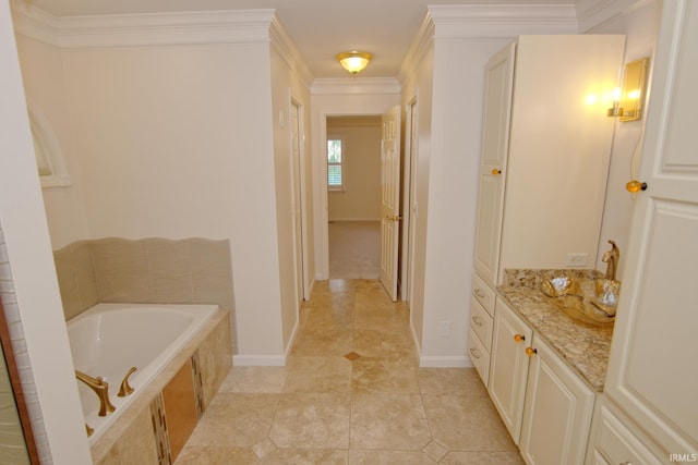 bathroom featuring tile patterned floors, vanity, ornamental molding, and a tub