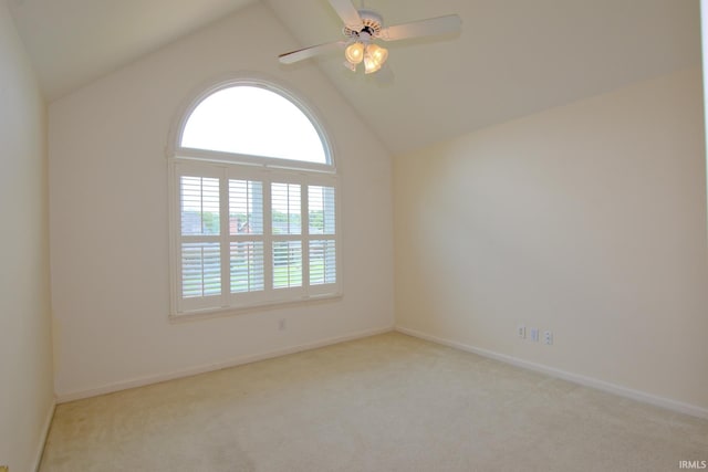 empty room featuring ceiling fan, light carpet, and vaulted ceiling