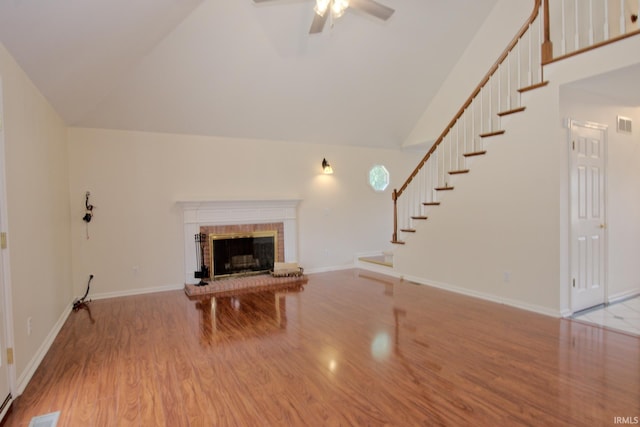 unfurnished living room with ceiling fan, a fireplace, lofted ceiling, and light hardwood / wood-style floors