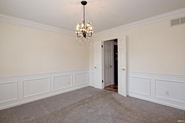 spare room with ornamental molding, an inviting chandelier, and carpet floors