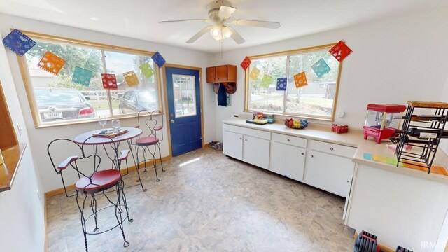 kitchen featuring ceiling fan and white cabinets