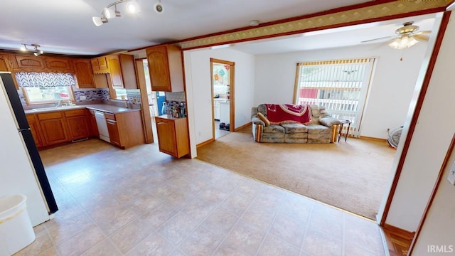 kitchen featuring light carpet, white appliances, light countertops, decorative backsplash, and brown cabinetry