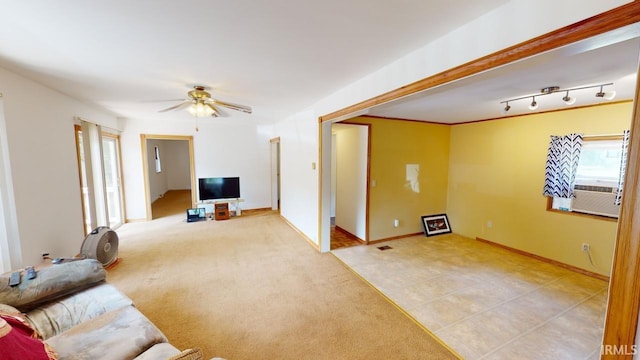 living room with light carpet, ceiling fan, baseboards, and cooling unit