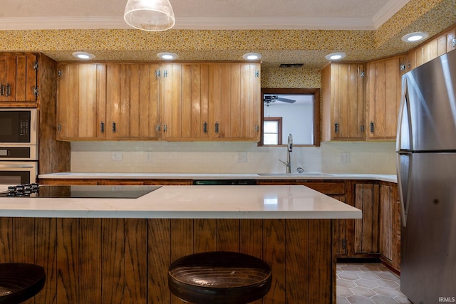 kitchen featuring black appliances, sink, decorative backsplash, and a breakfast bar