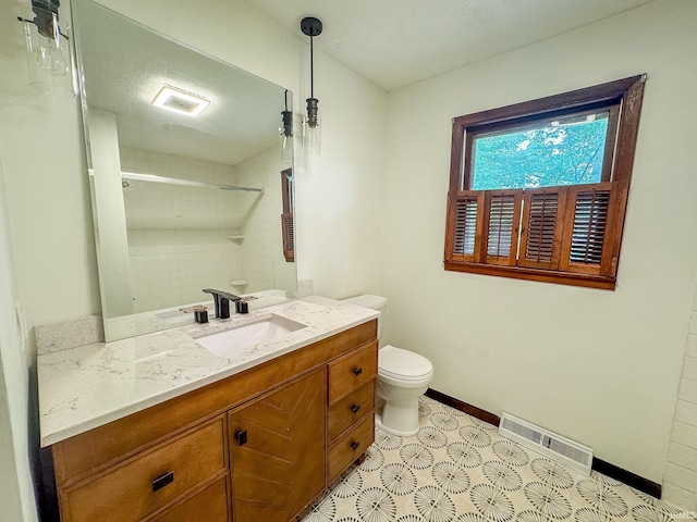 bathroom featuring vanity, tile patterned flooring, and toilet