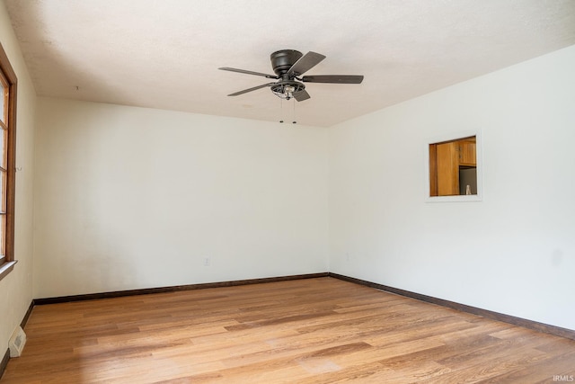 empty room with ceiling fan and light hardwood / wood-style floors