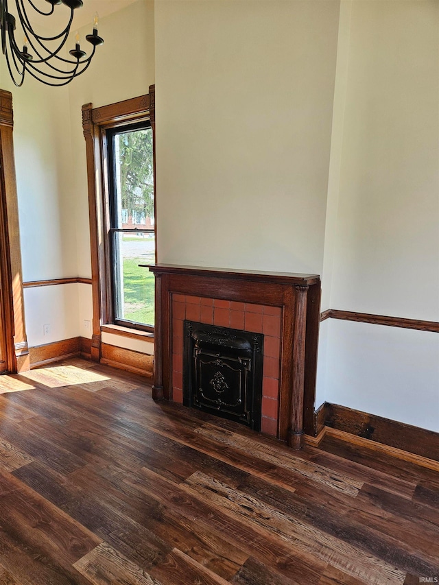 unfurnished living room with a tiled fireplace and wood-type flooring