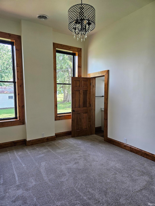 unfurnished bedroom featuring carpet and an inviting chandelier