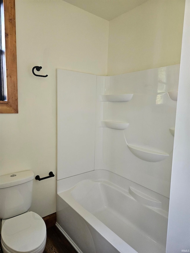 bathroom featuring toilet, hardwood / wood-style floors, and shower / washtub combination