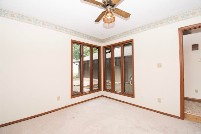 spare room with ceiling fan and light carpet