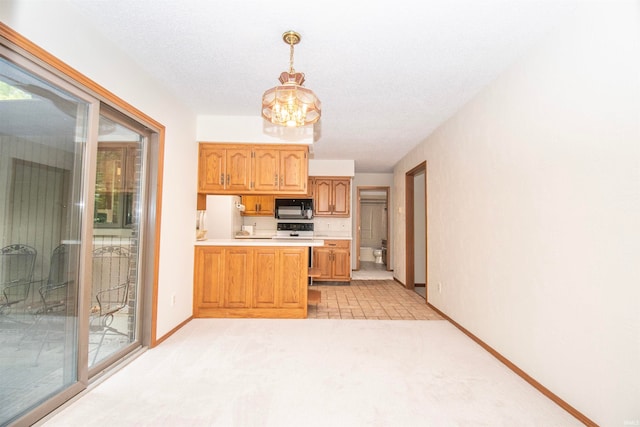 kitchen featuring kitchen peninsula, pendant lighting, and light carpet