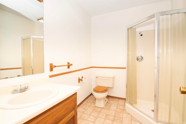 bathroom with a shower with door, toilet, vanity, and tile patterned floors