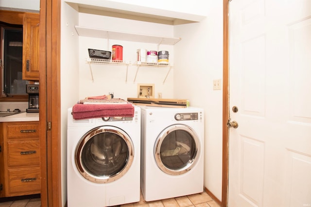 laundry room featuring light tile patterned flooring and washer and clothes dryer