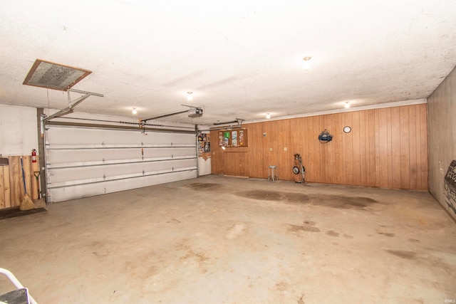 garage with wood walls and a garage door opener