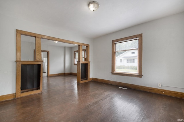 unfurnished living room with dark wood-type flooring