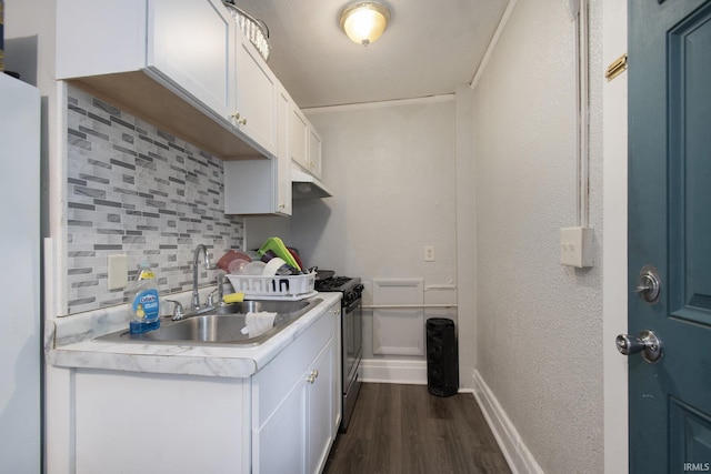 kitchen featuring sink, appliances with stainless steel finishes, dark hardwood / wood-style flooring, decorative backsplash, and white cabinets