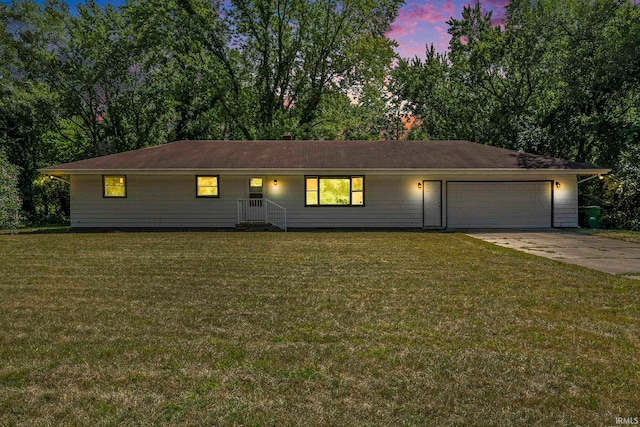 ranch-style house featuring a garage and a yard