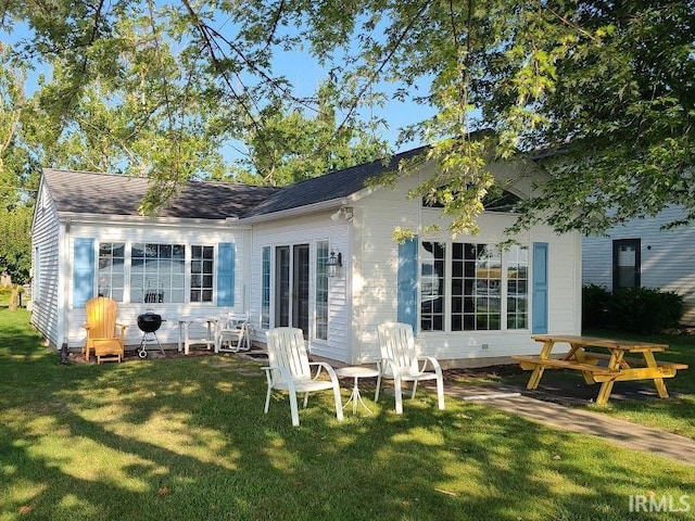 rear view of house featuring a lawn