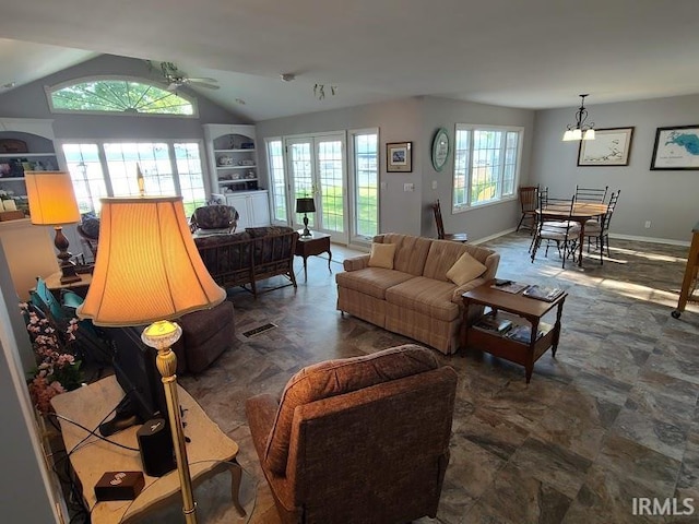 living room with ceiling fan with notable chandelier and lofted ceiling