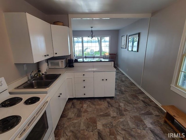 kitchen featuring white cabinets, white appliances, hanging light fixtures, and sink