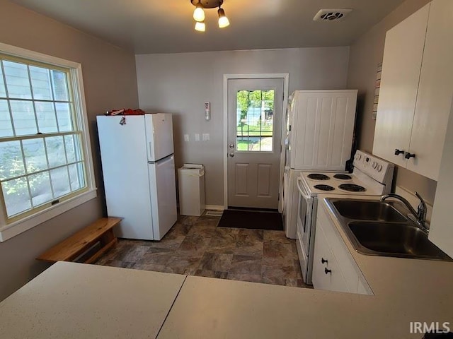 kitchen with white appliances, white cabinetry, and sink