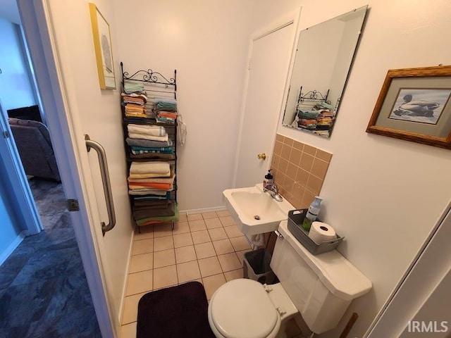 bathroom with backsplash, tile patterned flooring, sink, and toilet