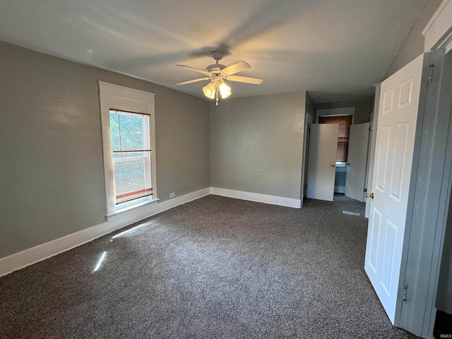 unfurnished room with dark carpet and ceiling fan