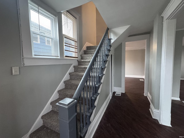 stairway with wood finished floors and baseboards