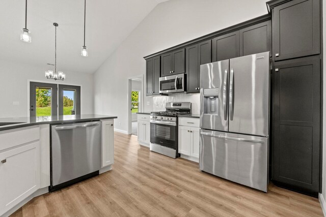 kitchen featuring white cabinets, stainless steel appliances, light hardwood / wood-style floors, and decorative light fixtures