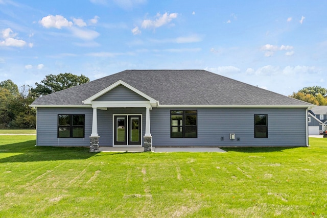 rear view of property featuring a lawn