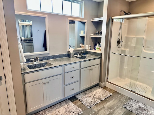 bathroom featuring walk in shower and dual bowl vanity