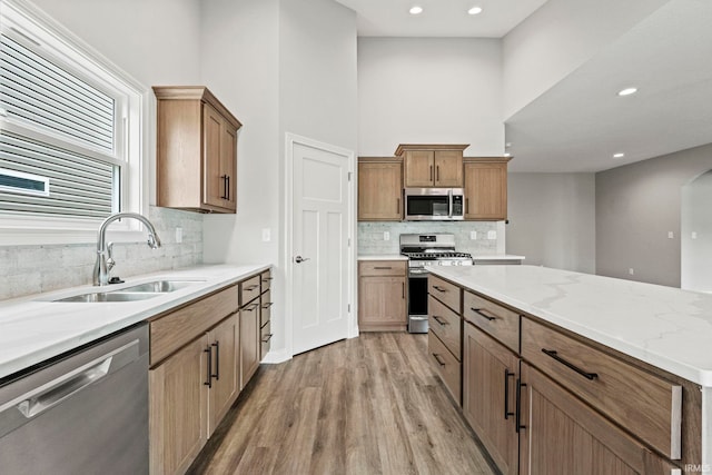 kitchen with light wood-style floors, appliances with stainless steel finishes, a sink, and recessed lighting