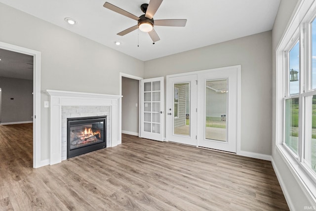 unfurnished living room featuring a fireplace, recessed lighting, ceiling fan, wood finished floors, and baseboards