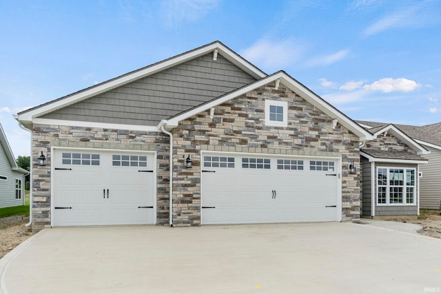 view of front of house featuring concrete driveway, stone siding, and an attached garage