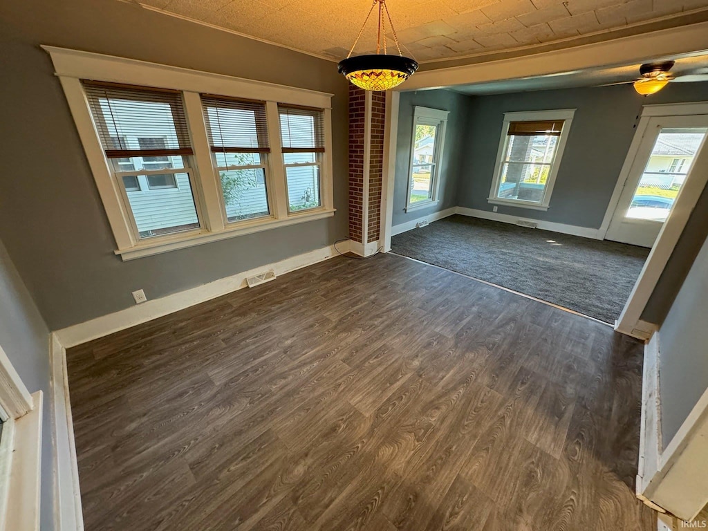 empty room with dark wood-type flooring and ceiling fan