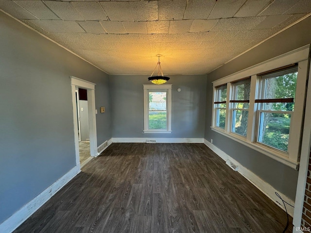 empty room featuring dark hardwood / wood-style floors and crown molding