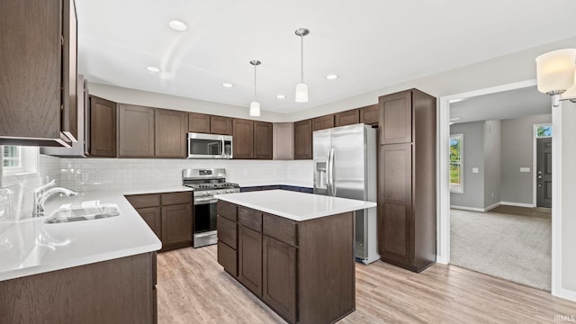 kitchen with sink, backsplash, a center island, stainless steel appliances, and dark brown cabinets