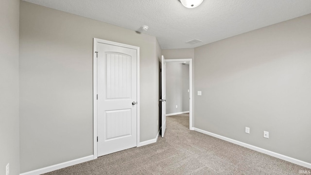 unfurnished bedroom featuring carpet floors and a textured ceiling