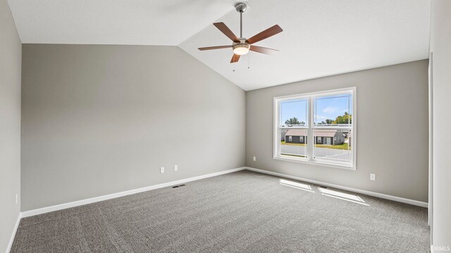 unfurnished room with ceiling fan, lofted ceiling, and carpet flooring