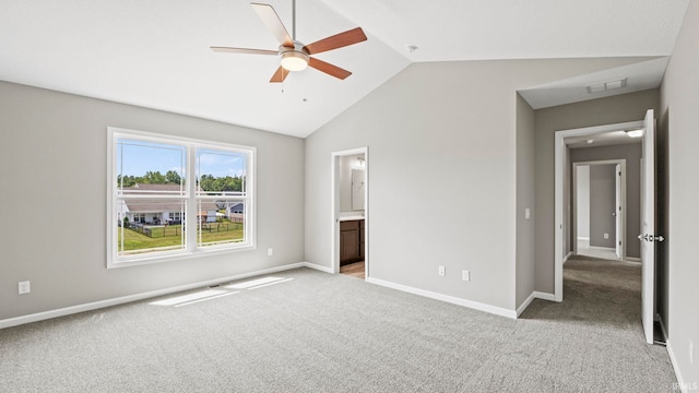 unfurnished bedroom with ceiling fan, ensuite bathroom, vaulted ceiling, and light carpet