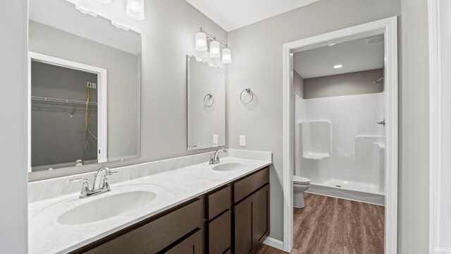 bathroom with vanity, hardwood / wood-style flooring, toilet, and walk in shower